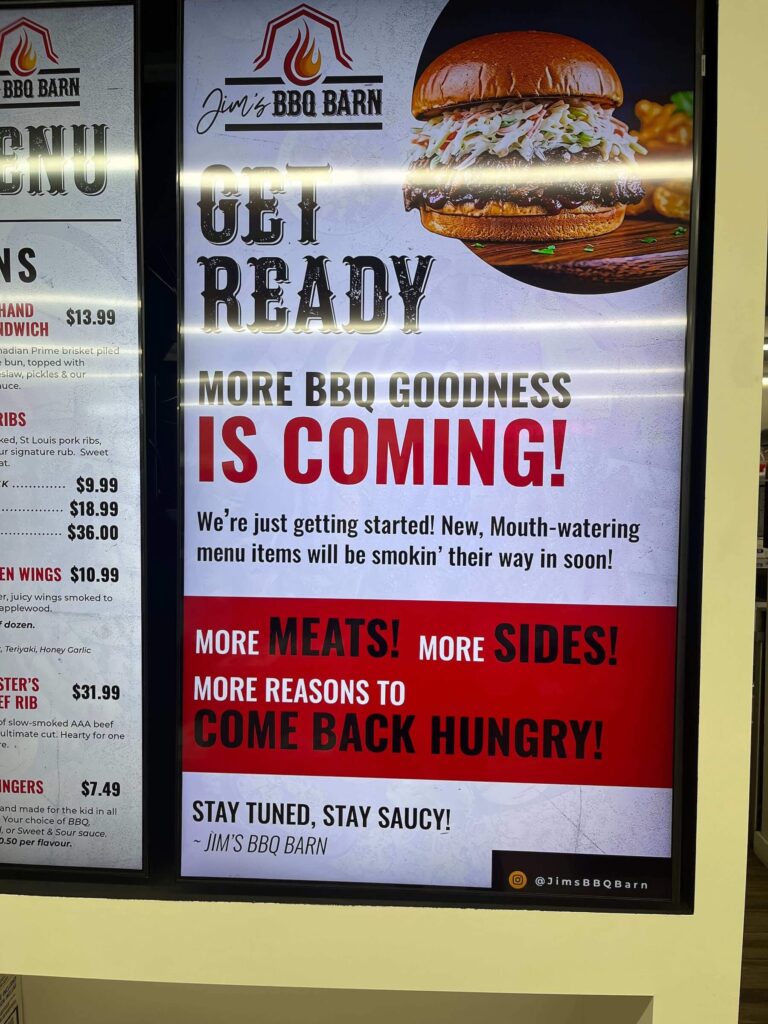 Sign at Jim’s BBQ Barn inside Jim’s Food Market in Little Fort, advertising smoked meats and BBQ sandwiches.